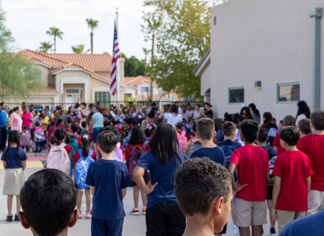 Students gather around the flag for the morning pledge at Milestones.